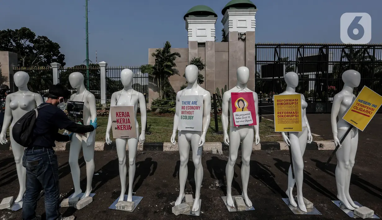 Aktivis Greenpeace Indonesia memasang poster pada puluhan maneken saat menggelar aksi damai di depan gerbang kompleks DPR, Jakarta Pusat, Senin (29/6/2020). Aksi tersebut dilakukan sebagai bentuk penolakan terhadap RUU Omnibus Law. (Liputan6.com/Johan Tallo)