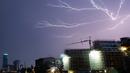 Sambaran petir selama badai terlihat di langit Berlin, Jerman (10/6/2019). (AFP Photo/dpa/Germany Out/Paul Zinken)