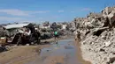 Komite ini akan diawasi oleh mantan koordinator perdamaian Timur Tengah Perserikatan Bangsa-Bangsa (PBB) asal Bulgaria, Nickolay Mladenov. Tampak dalam foto, para pengungsi Palestina hidup di tengah reruntuhan rumah dan bangunan yang hancur akibat serangan militer Israel selama lebih dari dua tahun di wilayah Gaza, di kamp pengungsi Jabalia, di bagian utara Jalur Gaza pada Sabtu 17 Januari 2026. (Omar AL-QATTAA/AFP)