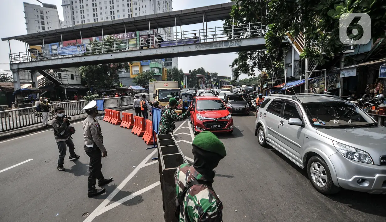 Petugas gabungan mengatur lalu lintas saat penyekatan mobilitas di Jalan Basuki Rahmat, Jakarta Timur, Kamis (15/7/2021). Polda Metro Jaya memperluas area penyekatan selama PPKM Darurat menjadi 100 titik mulai pukul 06.00-22.00 WIB guna mengurangi mobilitas. (merdeka.com/Iqbal S Nugroho)