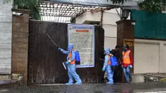 Pekerja otoritas sipil menyemprot disinfektan di pintu utama kediaman bintang Bollywood Amitabh Bachchan saat ia dinyatakan positif COVID-19 di Mumbai (12/7/2020).  Amitabh Bachchan dan putranya Abhishek Bachchan terpapar virus Corona Covid-19. (AFP/Sujit Jaiswal)