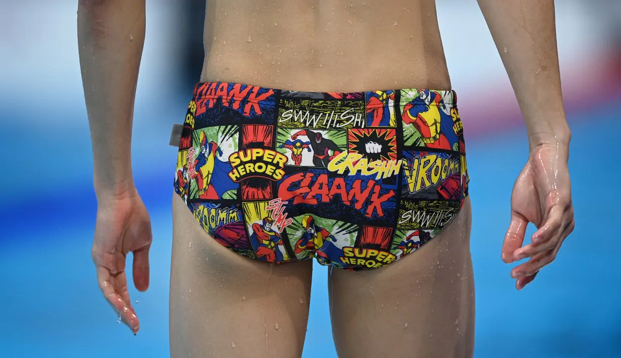 Seorang atlet renang memakai celana renang bergambar super hero saat mengikuti sesi latihan menjelang pertandingan renang Olimpiade Tokyo 2020 di Tokyo Aquatics Center, Senin (26/7/2021). (Foto: AFP/Oli Scarff)