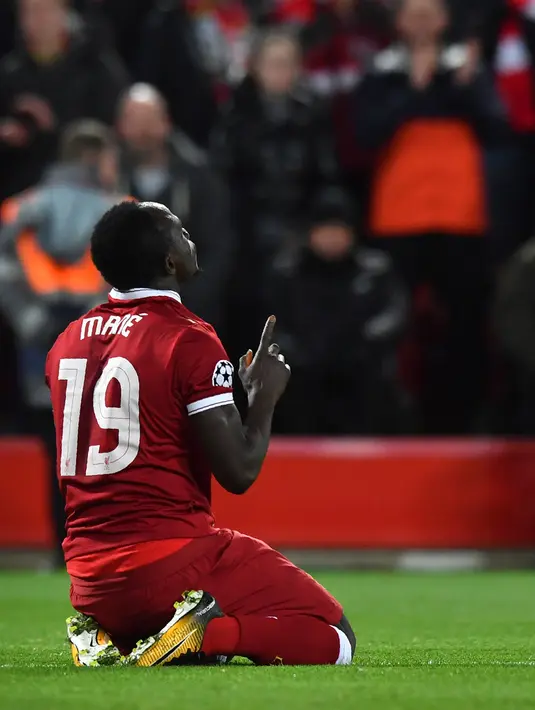 Pemain Liverpool, Sadio Mane mengacungkan jarinya setelah mencetak gol ke gawang Manchester City pada leg pertama perempat final Liga Champions di Anfield, Liverpool, Inggris, Rabu (4/4). Liverpool menang tiga gol tanpa balas. (Anthony Devlin/AFP)