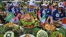 Berbagai peserta tampil kreatif dengan memadukan unsur olahraga sepak bola internasional bersama kekayaan kuliner khas Surabaya. Tampak dalam foto, para peserta yang mengenakan seragam tim sepak bola menyiapkan rujak uleg, salad gurih tradisional Indonesia yang berisi moncong sapi dan sayuran, dalam Festival Rujak Uleg 2026 di Surabaya, Jawa Timur, Sabtu 9 Mei 2026. (JUNI KRISWANTO/AFP)