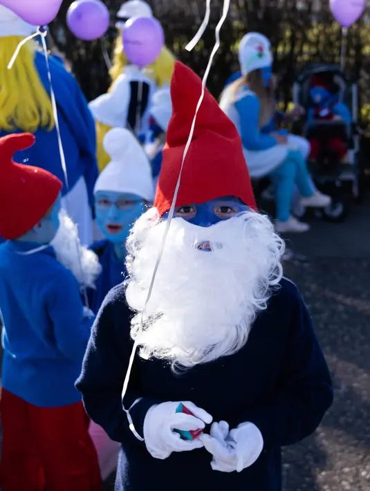 Seorang anak berpakaian dan berdandan seperti Smurf dalam upaya pemecahan rekor dunia di Lauchringen, Jerman, 16 Februari 2019. Kegiatan itu diklaim memecahkarn rekor dengan mengumpulkan 2.762 orang berbusana ala Smurf. (CONSTANT FORME-BECHERAT/AFP)