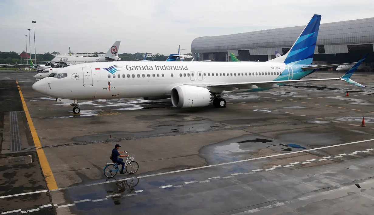 Seorang pegawai mengendarai sepeda melewati pesawat Boeing 737 Max 8 Garuda Indonesia yang terparkir di Bandara Soekarno Hatta, Tangerang, Rabu (13/3). Pemerintah masih mengecek Boeing 737 Max 8 yang terdapat di Indonesia. (REUTERS/Willy Kurniawan)
