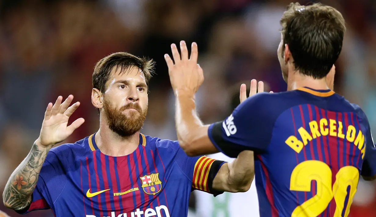 Pemain Barcelona, Sergi Roberto dan Lionel Messi dalam laga pekan pertama Liga Spanyol melawan Real Betis di Stadion Camp Nou, Minggu (20/8). Di belakang jersey mereka hanya bertuliskan ‘Barcelona’ untuk mengingat kota tercinta. (AP Photo/Manu Fernandez)