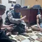 Personel Polres Indragiri Hilir mendatangi rumah warga yang diserang buaya saat mandi. (Liputan6.com/M Syukur)