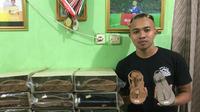 Pemain Persita Tangerang, Redi Rusmawan, bersama produksi sandal yang merupakan bisnis keluarganya. (Bola.com/Permana Kusumadijaya)
