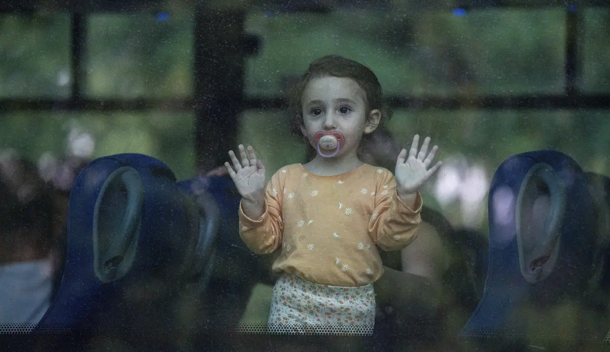 Seorang gadis kecil, dengan dot di mulutnya, adalah salah satu dari sekian banyak orang yang pada hari Jumat mengungsi dari kota Kiryat Shmona, Israel utara, setelah tiga warganya terluka akibat tembakan lintas batas dari militan di Lebanon. (AP Photo/Baz Ratner)