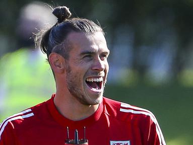 Pemain Timnas Wales, Gareth Bale, tertawa saat mengikuti latihan jelang laga UEFA Nations League di Hensol, South Wales, Senin (31/8/2020). Wales akan berhadapan dengan Finlandia. (AFP/Geoff Caddick)