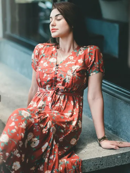Meski dengan makeup tipis yang berkesan natural, penampilan istri Jerinx SID dengan gaun merah bermotif bunga ini membuatnya tetap memesona. (Liputan6.com/IG/ncdpapl)
