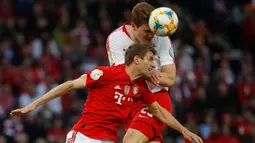 Striker Bayern Munchen, Thomas Mueller, duel udara dengan bek RB Leipzig, Marcel Halstenberg, pada laga DFB Pokal di Stadion Olympic, Berlin, Sabtu (25/5). Munchen menang 3-0 atas Leipzig. (AFP/Odd Andersen)