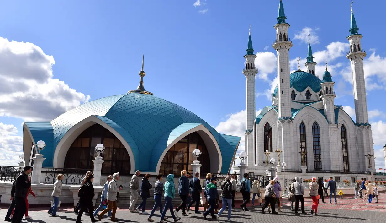 Wisatawan mengunjungi masjid Kul Sharif yang terletak di Kazan, Rusia. Masjid Kul Sharif yang didominasi warna putih dan biru laut ini dibangun pada tahun 1996 dan selesai pada 2005 lalu. (Photo by SAEED KHAN / AFP)