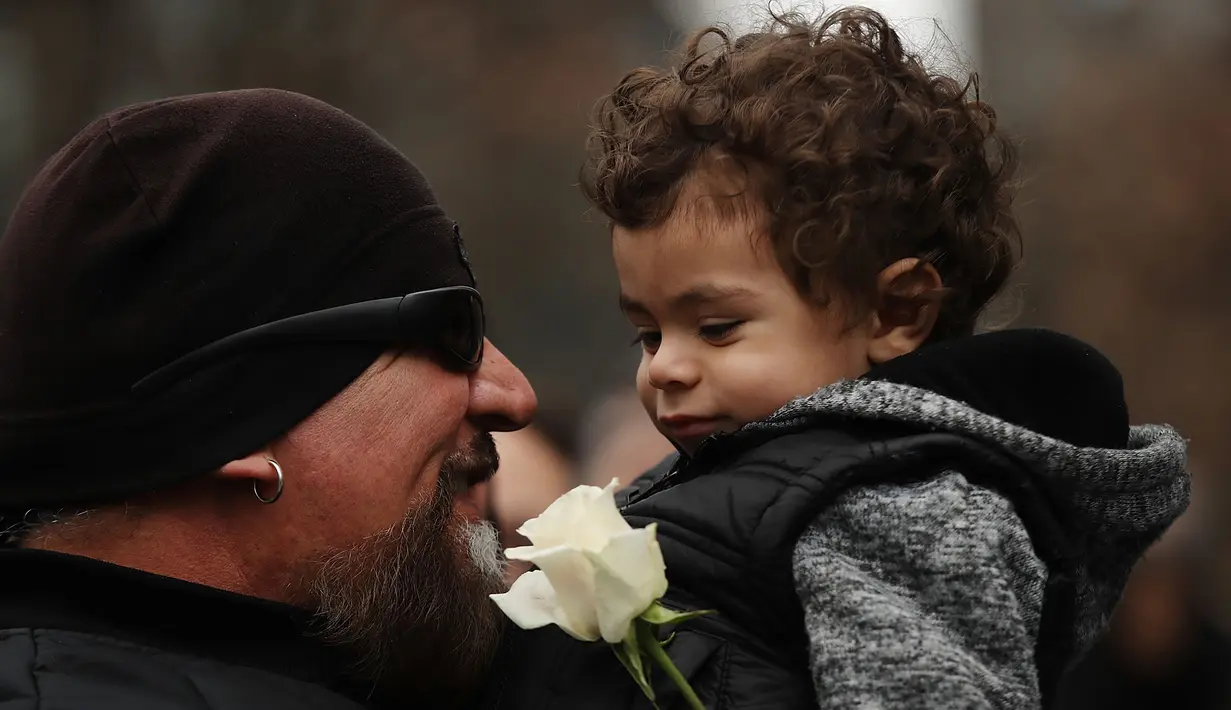 Patrick Rodriguez yang kehilangan saudaranya, Monica, memegang Nicholas (2) dalam upacara peringatan 25 tahun serangan bom truk di WTC, New York City, Amerika Serikat, Senin (26/2). (Spencer Platt/Getty Images/AFP)