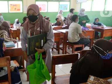 Wali murid siswa Sekolah SD kelas 4,5 dan 6 usai mengambil rapot secara bergilir di Sekolah Islam Raudlatul Hikmah, Parakan, Pondok Benda, Pamulang, Tangerang Selatan, Banten, Jumat (16/10/2020). (merdeka.com/Dwi Narwoko)