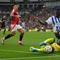 Kiper Manchester United, Andre Onana, saat mematahkan serangan Brighton and Hove Albion yang dibangun gelandang Yankuba Minteh, pada laga pekan kedua Premier League di&nbsp;American Express Stadium, Sabtu (24/8/2024) malam WIB. (AFP/Glyn Kirk)