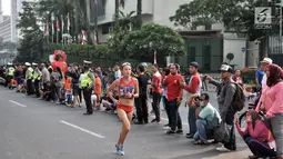 Warga menyaksikan lomba lari maraton putri Asian Games 2018 di kawasan MH Thamrin, Jakarta, Minggu (26/8). Meski Car Free Day ditiadakan, warga Ibu Kota tetap memadati kawasan MH Thamrin menyaksikan maraton Asian Games 2018. (Merdeka.com/Iqbal S. Nugroho)