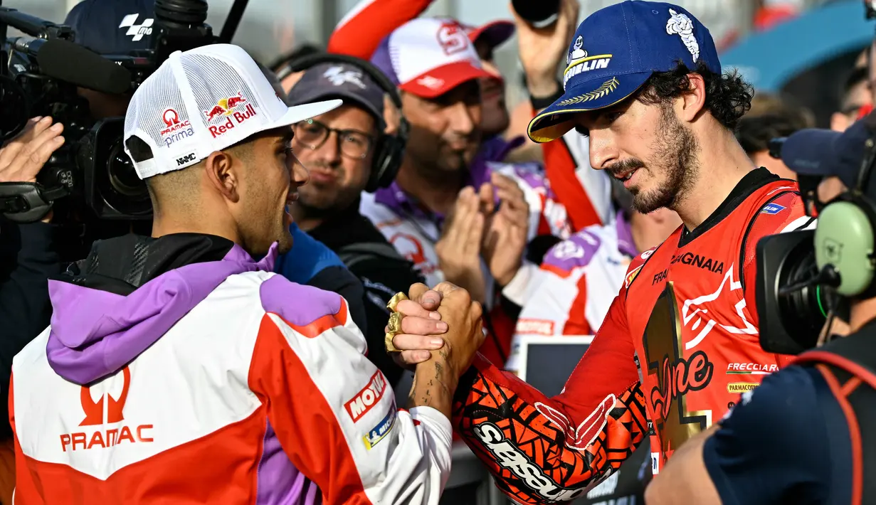 Pembalap Ducati Lenovo, Francesco Bagnaia (kanan), mendapatkan selamat dari Jorge Martin yang merupakan rivalnya musim ini setelah balapan MotoGP Valencia, Minggu (26/11/2023). (AFP/Javier Soriano)