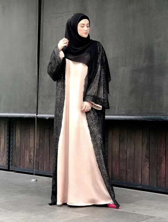 Tampil dengan gamis hitam yang dipadukan warna nude, gaya Mulan Jameela ini bisa dipakai di acara formal ataupun santai. Dirinya juga memilih menggunakan hijab dengan model yang cukup simpel pada penampilannya. (Liputan6.com/IG/@mulanjameela1)