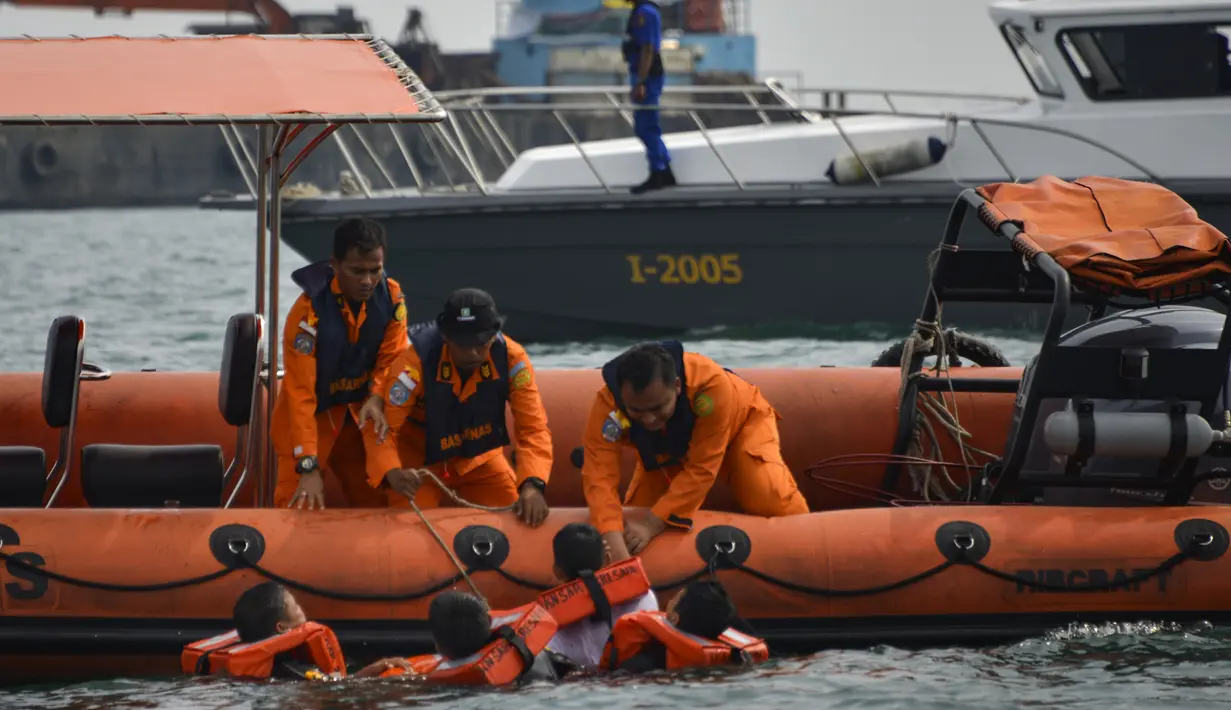 Personel Basarnas mengevakuasi korban selama simulasi penyelamatan pengungsi luar negeri di perairan Banda Aceh, Kamis (17/10/2019). Kegiatan diikuti peserta dari lintas stake holder terkait, termasuk unsur TNI, Polri, relawan dan pimpinan lembaga peduli bencana di Aceh. (CHAIDEER MAHYUDDIN/AFP)