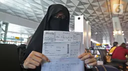 Calon penumpang dengan izin khusus kembali ke daerah asal usai pendidikan di Arab Saudi menunjukan surat syarat terbang di Terminal 3 Bandara Soekarno Hatta, Tangerang, Kamis (7/5/2020). Pemerintah membuka kembali penerbangan domestik dengan penumpang bersyarat. (Liputan6.com/Herman Zakharia)