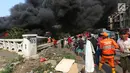 Warga membantu petugas pemadam kebakaran menjinakkan api yang membakar sebuah gudang di Jalan Kampung Bandan, Ancol, Jakarta Utara, Kamis (5/7). Belum diketahui ada atau tidaknya korban dalam kebakaran tersebut. (Kapanlagi.com/Budy Santoso)