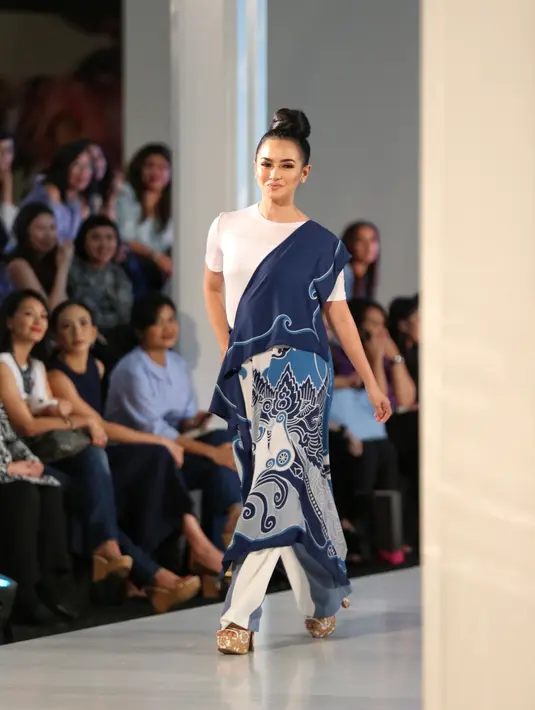 Coba lihat gaya Ririn saat berlenggang di atas catwalk. Senyumannya yang semringah membuat penampilan Ririn semakin cantik dan memikat. (Adrian Putra/Bintang.com)