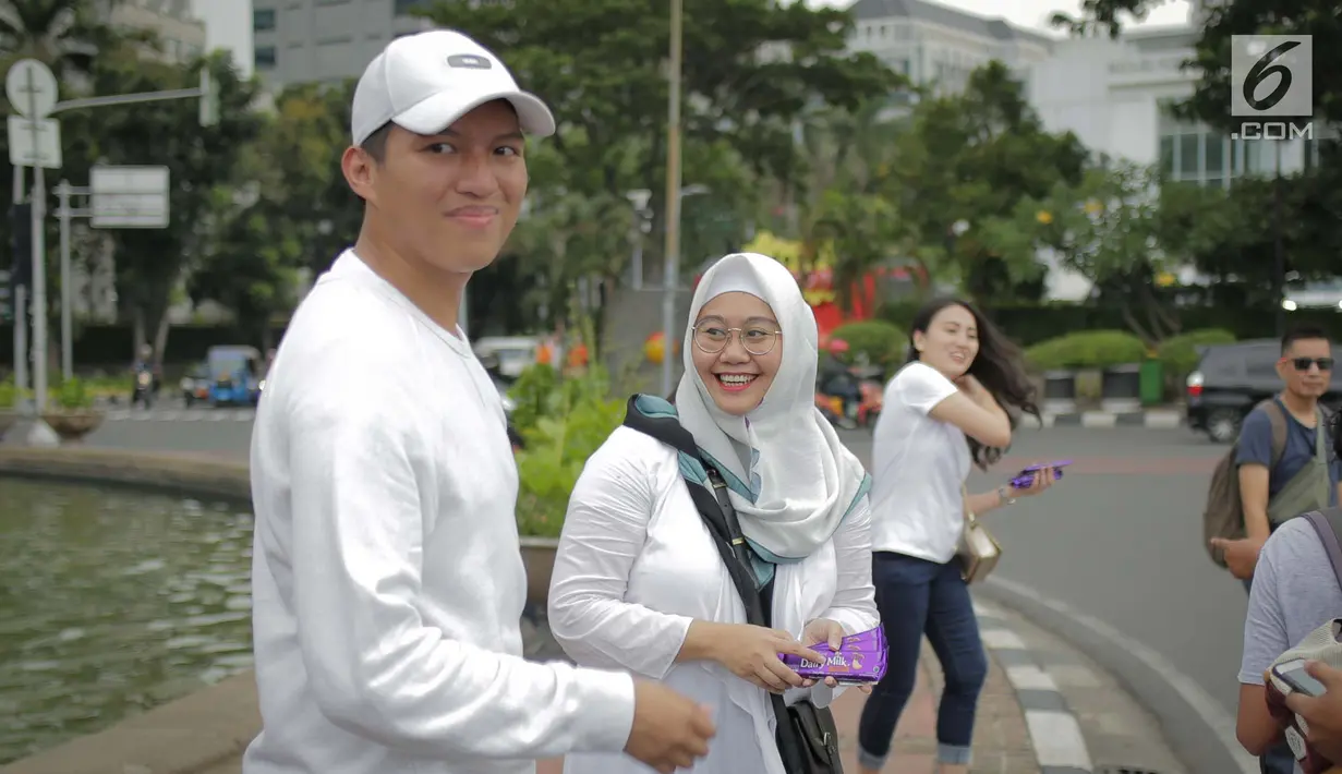 Relawan yang tergabung dalam Kita Satu Relawan Millennial Jokowi-Amin saat membagikan cokelat di kawasan Patung Kuda, Jakarta, Kamis (18/4). Kegiatan tersebut sebagai bentuk terima kasih kepada seluruh anak bangsa yang telah ikut memberikan suaranya di TPS. (Liputan6.com/Faizal Fanani)