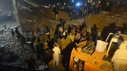 Tim SAR dibantu warga mencari korban di reruntuhan pabrik berlantai lima yang ambruk di Lahore, Pakistan Timur, Rabu (4/11) malam waktu setempat. Sedikitnya 16 orang tewas dan 40 luka-luka akibat kejadian tersebut. (AFP PHOTO/Arif Ali)