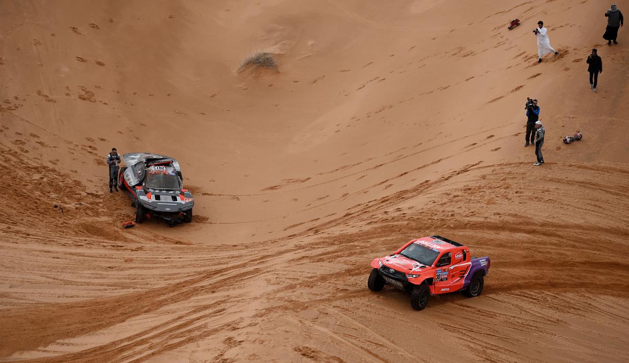 Kejadian itu bermula saat Carlos Sainz memacu mobilnya melewati beberapa gundukan pasir. Ia kemudian melakukan lompatan yang cukup tinggi namun gagal mendarat dengan baik. Bagian depan mobil Audi RS Q e-tron E2 yang dikendarainya menghantam pasir dan membuatnya terbalik. (AFP/Franck Fife)