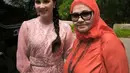 Arumi Bachsin tampil mengenakan dress pink salmon. Ia berfoto bersama ibundanya yang mengenakan kerudung dan baju orange. [@arumibachsin_94]