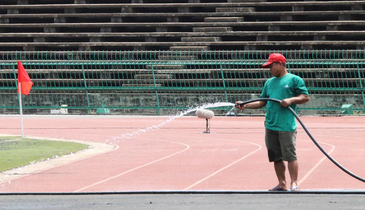 Pekerja menyiram rumput di Stadion National Olympic, Phnom Penh, Rabu (20/2). Stadion ini menjadi salah satu venue yang menggelar laga Piala AFF U-22 2019. (Bola.com/Zulfirdaus Harahap)