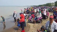 Warga berkerumun menantikan evakuasi pesawat Lion Air JT 610 di Pantai Pakis Jaya, Karawang, Jawa Barat, Senin (29/10). Warga yang penasaran berduyun-duyun datang ke pantai dekat lokasi jatuhnya pesawat. (Liputan6.com/Herman Zakharia)