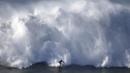 Seorang atlet meluncur di depan gelombang raksasa di Pantai Praia do Norte, Nazare, Portugal, (29/11/2015). (Reuters/Rafael Marchante)