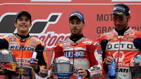 Pembalap Ducati, Andrea Dovizioso (tengah) berpose diatas podium dengan pembalap Honda Marc Marquez dan Danilo Petrucci usai memenangi MotoGP Jepang di sirkuit Motegi (15/10). (AFP Photo/Toshifumi Kitamura)