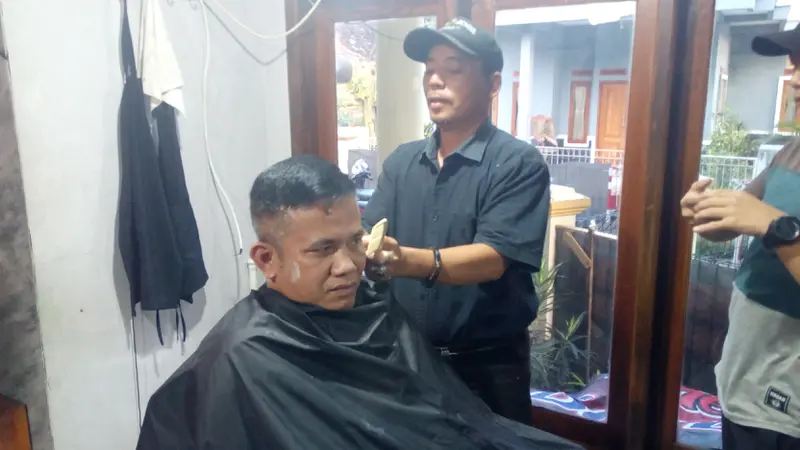 Abah Atrox tengah mempraktekan potongan rambut