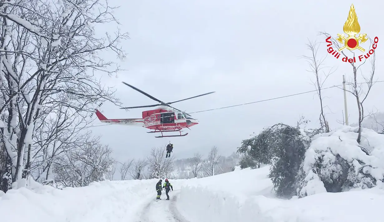 Sebuah helikopter saat mengevakuasi seorang yang berada di hotel Rigopiano setelah diterjang longsor salju, Farindola, Italia (19/1). (AFP Photo/vigili del Fuoco/Handout)