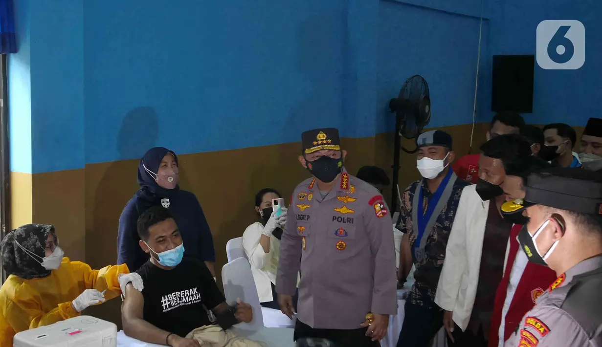 Kapolri Jenderal Pol Listyo Sigit Prabowo memberi sambutan saat meninjau gelaran Vaksin Covid-19 Serentak di GOR Radio Dalam, Jakarta Selatan, Selasa (8/3/2022). Vaksinasi tersebut serentak digelar di seluruh Indonesia yang diselenggarakan oleh Kepolisian RI.  (Liputan6.com/Herman Zakharia)