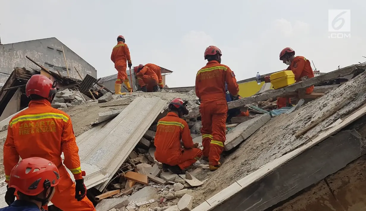 Sejumlah petugas damkar saat mengevakuasi korban rumah roboh di  Jalan Pulo, Tanah Tinggi, Johar Baru, Jakarta Pusa, Jumat (26/4). Menurut saksi mata mengatakan rumah tersebut sedang dalam proses pembangunan yang sudah dilakukan selama kurang lebih satu tahun. (Liputan6.com/Herman Zakharia)