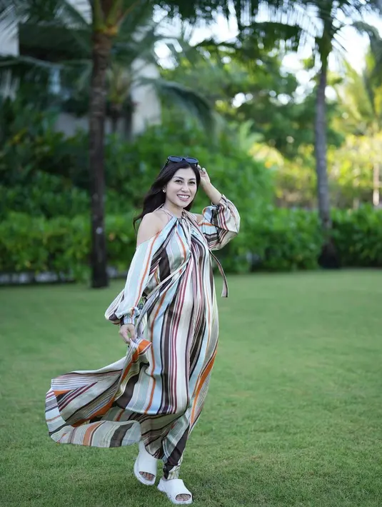 Nisya Ahmad tampil dengan long dress bermotif garis yang elegan. Dress Nisya ini memiliki detail cut-out di bagian lengan, menambah nuansa musim panas yang cantik. Foto: Instagram.