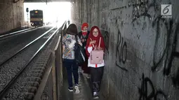 Pejalan kaki melintasi jalan setapak di sekitar Stasiun Cawang, Jakarta, Kamis (9/5). Meskipun sempit, jalan setapak tersebut masih menjadi pilihan sebagian pejalan kaki untuk menyeberangi Jalan Gatot Soebroto, dibanding harus melewati JPO yang jaraknya lebih jauh. (Liputan6.com/Immanuel Antonius)
