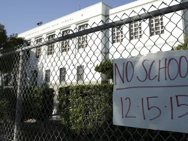 Sebuah kertas berisi pemberitahuan libur terpasang di Florence Nightingale Middle School, Los Angeles, Selasa (15/12). Seluruh sekolah di Los Angeles, ditutup selama satu hari pada Selasa (15/12), karena adanya ancaman teror bom. (REUTERS/Jason Redmond)
