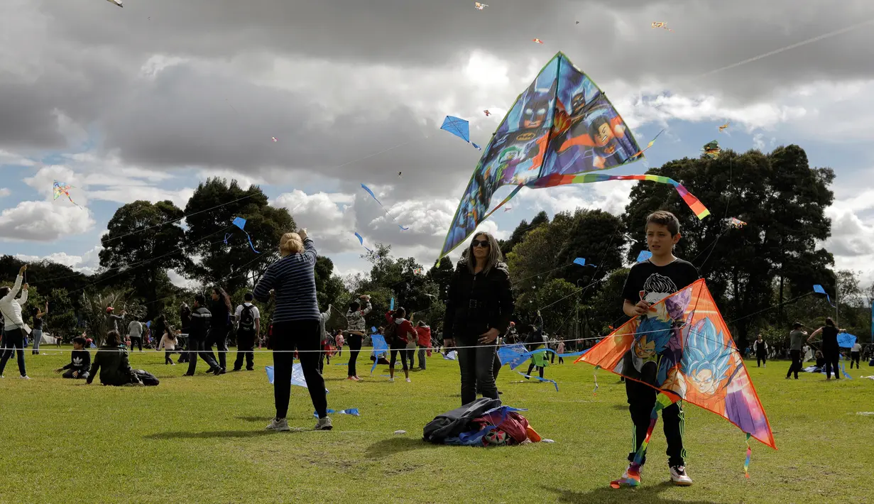 Orang-orang menerbangkan layang-layang selama festival musim panas di taman Simon Bolivar, Bogota, 12 Agustus 2018. Menikmati musim panas, menerbangkan layang-layang tetap menjadi kegiatan utama yang harus dilakukan. (AFP PHOTO/John VIZCAINO)