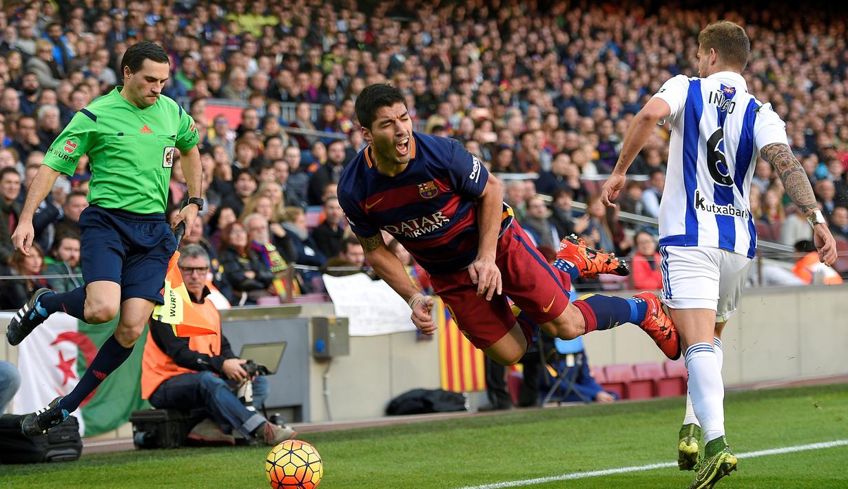 Luis Suarez dijatuhkan pemain Real Sociedad, Inigo Martinez, dalam lanjutan La Liga Spanyol di Stadion Camp Nou, Barcelona, Sabtu (28/11/2015). (AFP/Lluis Gene)
