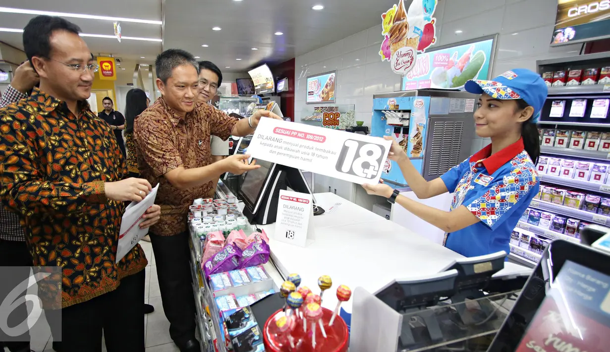 Direktur Marketing PT Indomarco Prismatama Wiwiek Yusuf dan Direktur Hubungan Eksternal PT HM Sampoerna Tbk. Yos Adiguna Ginting menyerahkan papan peraturan penjualan rokok di gerai Indomaret, Jakarta, Selasa (3/11). (Liputan6.com/Immanuel Antonius)