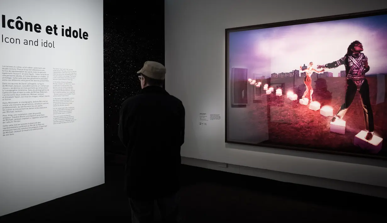Pengunjung membaca informasi di dekat foto Michael Jackson karya David LaChapelle dalam pameran On The Wall di museum Grand Palais, Paris, Rabu (21/11). Pameran tersebut digelar dari 23 November hingga 14 Februari 2019 mendatang. (Philippe LOPEZ/AFP)