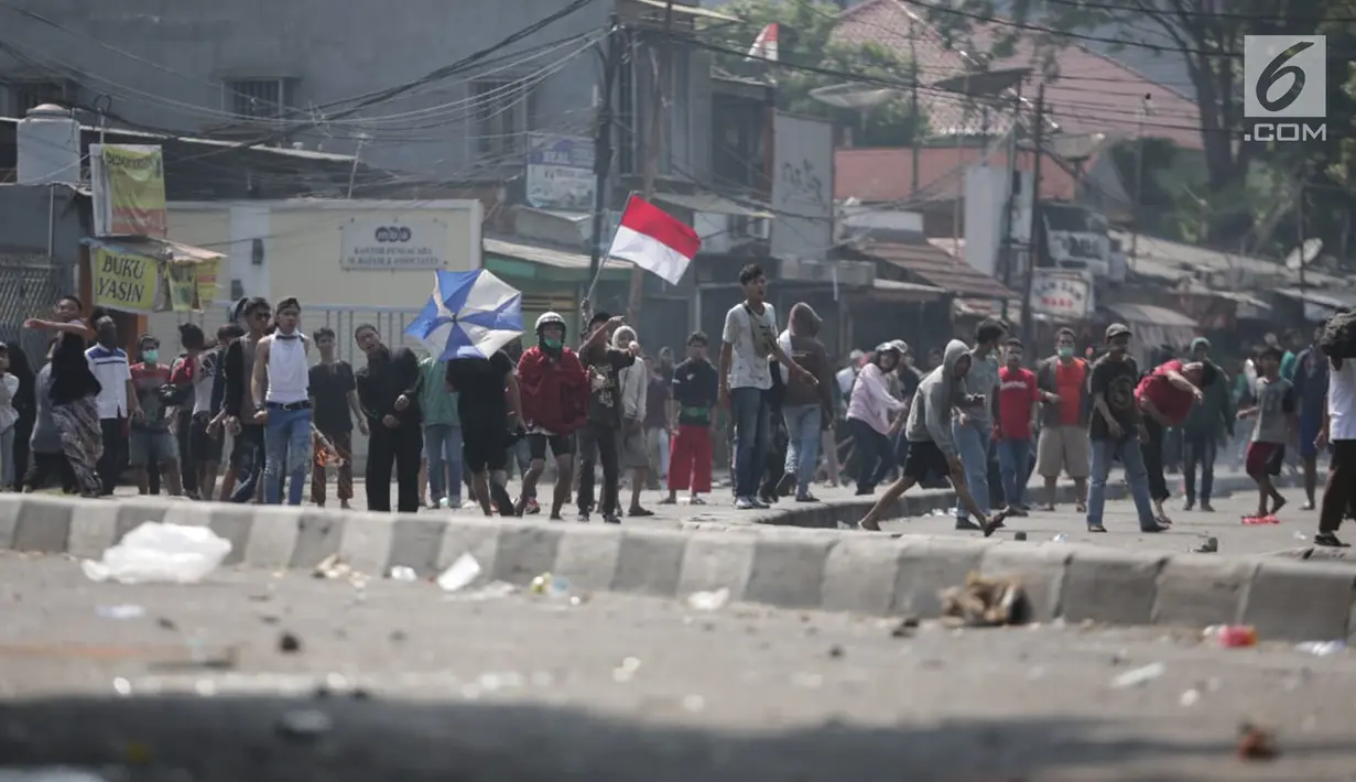 Massa aksi melemparkan batu ke arah petugas selama demo di Petamburan, Jakarta Barat, Rabu (22/5/2019). Massa aksi masih melakukan perlawanan sejak dipukul mundur oleh pihak kepolisian, dini hari tadi. (Liputan6.com/Faizal Fanani)