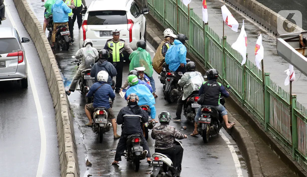 Petugas kepolisian lalu lintas merazia pengendara sepeda motor yang melintasi jalur bus Transjakarta di Jalan Sultan Agung, Manggarai, Jakarta, Kamis (6/2/2020). Meski melanggar, sebagian pengguna jalan secara sengaja masuk dan menggunakan jalur khusus bus tersebut. (Liputan6.com/Helmi Fithriansyah)