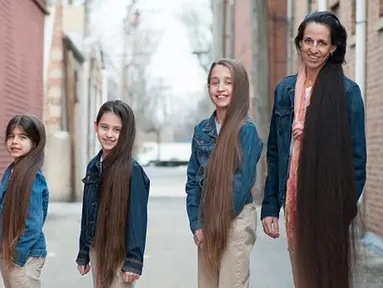 Terelynn Russel (43) berpose dengan ketiga putrinya di kediamannya di Illinois, Amerika Serikat. Seumur hidupnya, Tere tidak pernah sekalipun menggunting rambutnya yang kini sudah hampir menyentuh tumit dengan panjang 1,87 meter. (dailymail.co.uk)